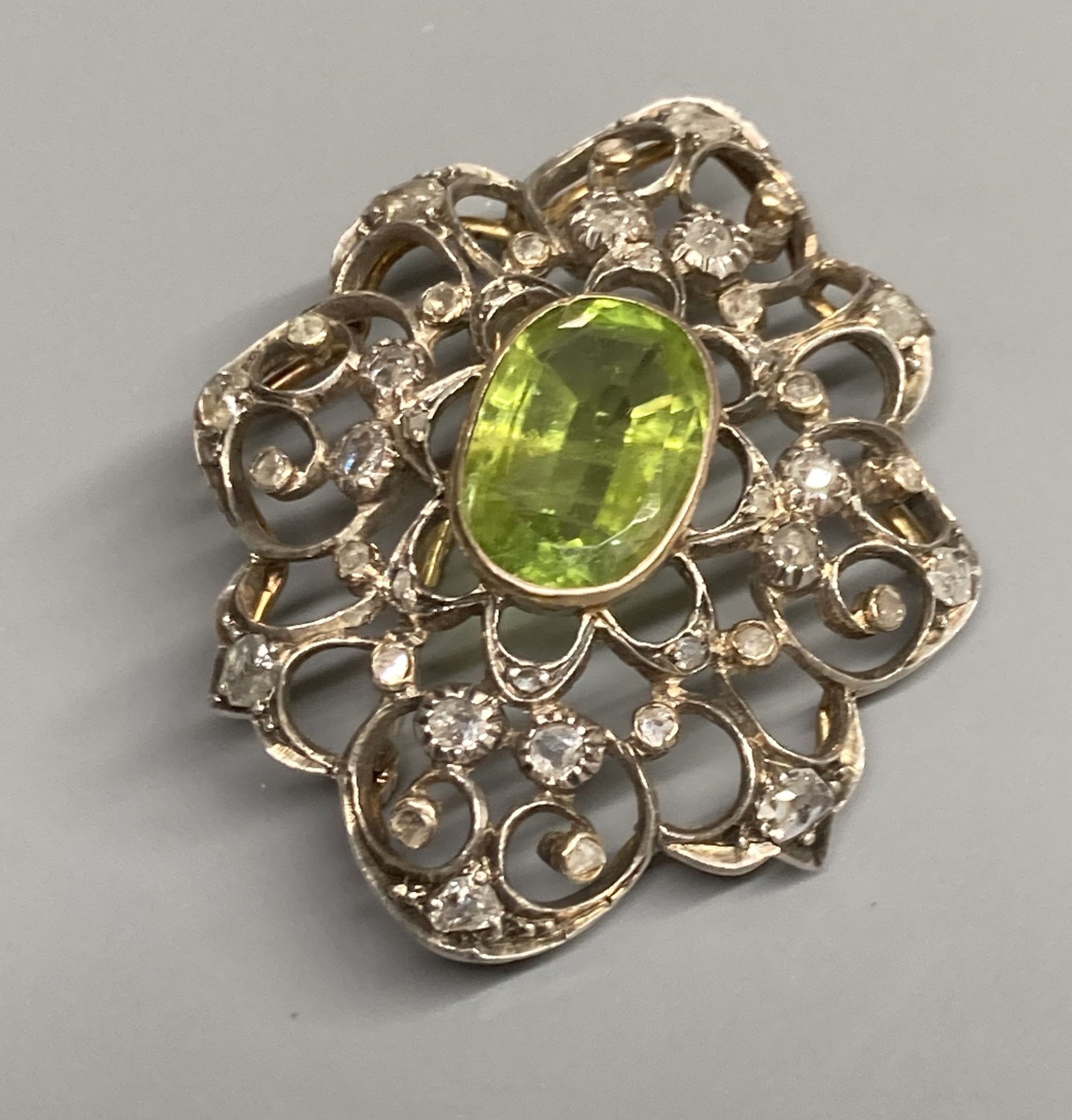 An early to mid 20th century Austro-Hungarian? white and yellow metal peridot and diamond set brooch, 38mm, gross 9 grams.